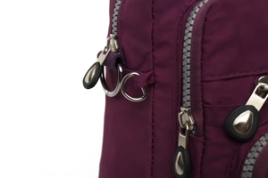 Détail de fermeture éclair argentée et anneau D sur sac à langer en nylon violet