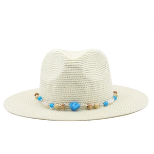 Close-up of woven straw hat with bohemian colorful beads and rustic string detail