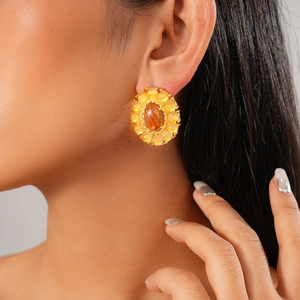 Close-up of vintage style oval agate gold cluster earrings worn by a model