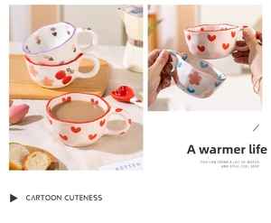 Close-up of wavy ceramic mugs with hand-painted floral heart patterns for afternoon tea