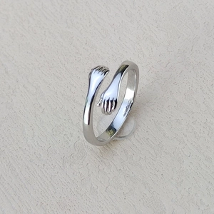 Adjustable silver embrace hands ring for couples with a polished romantic hugging design