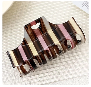 Macro view of checkered claw clip with pink and beige stripes and heart cutout
