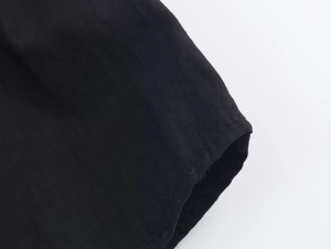 Macro shot of black poplin fabric texture and neat flat stitching on the shirt edge