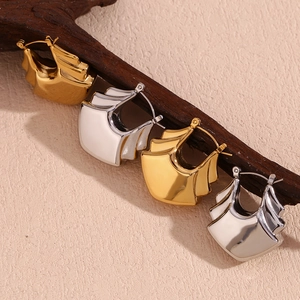Detailed view of layered wavy fan-shaped earrings in gold and silver finishes