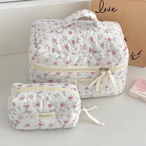 Detailed set of two quilted floral makeup bags with rose patterns and top handles