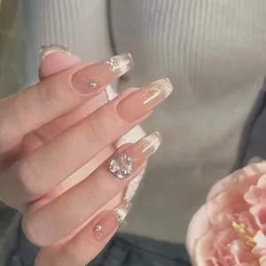Details von rosa Ombre-Kunstnägeln mit silbernem Glitzer und großem Herz-Strassstein