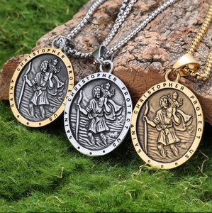 Three Saint Christopher pendants in gold, silver, and bicolor finish on natural moss