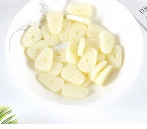 Close-up of teardrop PVC garlic slice miniatures with holes for DIY craft accessories