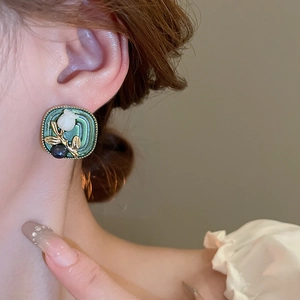 Close-up of vintage square tulip earrings with green enamel and purple bead detailing
