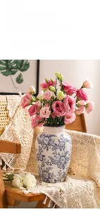 Dettaglio di vaso in ceramica bianca e blu con smalto craquelé e fiori di lisianthus rosa