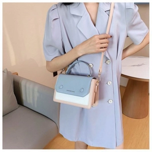 Detail of color-block leather bag with logo print and adjustable shoulder strap