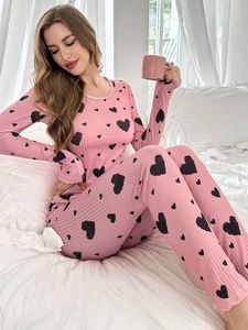 Detail of pink long-sleeve loungewear set featuring ribbed fabric and black heart prints