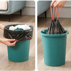 Thick black drawstring trash bags for kitchen waste shown being fitted and lifted