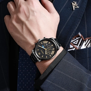 Close-up of black steel watch with gold Roman numerals worn with a navy pinstripe suit