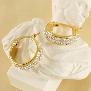 18K gold plated double row rhinestone hoop earrings in stainless steel on a white sculpture
