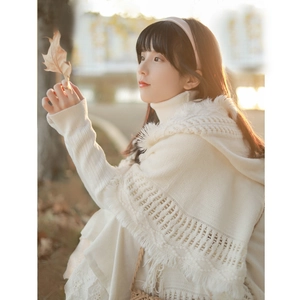 Bohemian knit poncho with tassels and hollow details worn by a woman in autumn setting