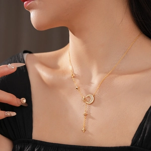 Close-up of golden Y-shaped necklace featuring zircon-encrusted moon and star charms