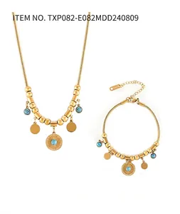 Close-up of S.STEEL engraving and blue turquoise charms on gold-plated jewelry set