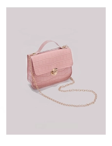 Detail of pink crocodile embossed leather texture and gold metal clasp on small handbag