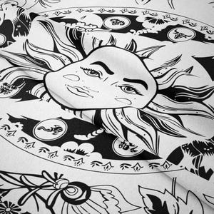Detail of woven tapestry showing sun face and astrological tarot patterns in black and white
