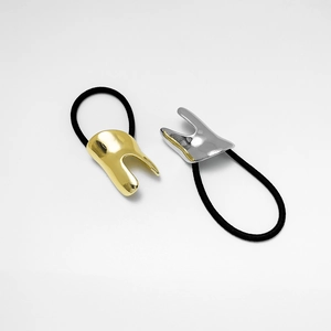 Detail of U-shaped gold and silver alloy metal clasps on thick black elastic hair ties