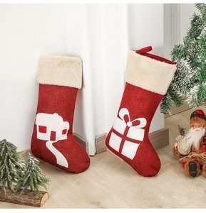 Detail of burlap Christmas stockings with white house applique and faux fur trim