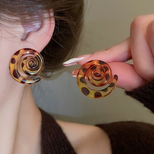 Close-up of retro spiral resin stud earrings with leopard tortoiseshell texture pattern