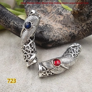 Detailed view of Tibetan silver curved tube beads with ethnic hollow patterns and resin inlay