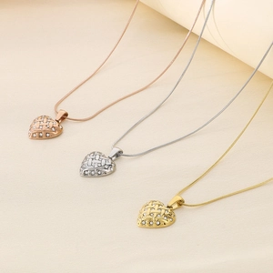 Three heart-shaped pendant necklaces in rose gold, silver, and gold on thin snake chains