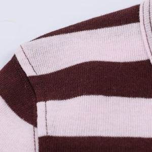 Detailed close-up of brown and pink striped knit fabric shoulder seams and texture