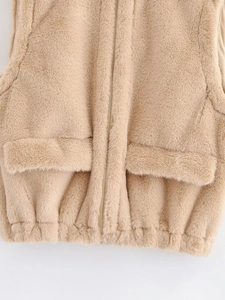 Détail du gilet en fausse fourrure beige avec fermeture éclair et poches symétriques