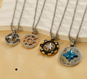 Detail of nautical stainless steel compass pendants and helm charms on display