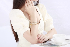 Close-up of a gold-plated stainless steel cuff bracelet with rhinestones on a woman's wrist