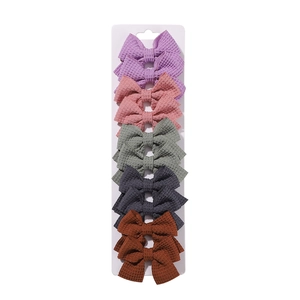 Detailed view of 10-piece waffle knit bow hair clips set in five soft pastel colors