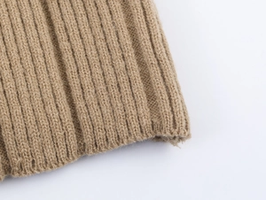 Macro shot of camel ribbed knit fabric texture showing premium wool blend fibers