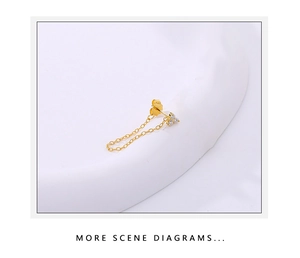 Detailed close-up of golden 925 silver chain fringe earrings with three clear zircons