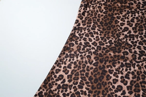 Macro detail of leopard print fabric showing rich texture and brown leopard pattern