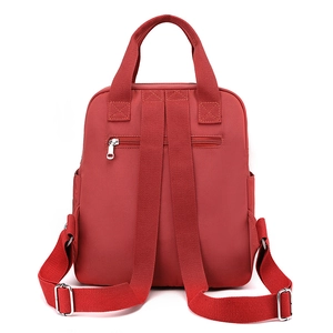 Red nylon quilted backpack with top handle and adjustable straps shown from back view