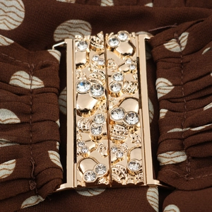 Elegant polka dot dress featuring a golden skull buckle with sparkling rhinestones