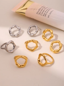 Flat lay of geometric irregular wavy rings in polished gold and silver steel finish