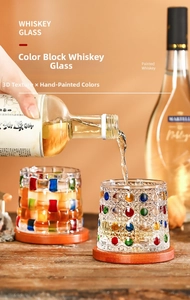 Detailed view of hand-painted whiskey glasses with colorful patterns and wooden coaster