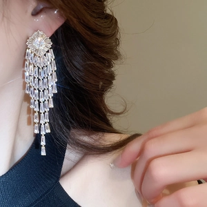 Close-up of dangling silver-plated tassel earrings with brilliant cubic zirconia inlays