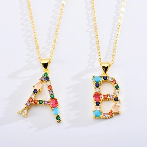 Elegant gold letter A and B necklaces with colorful zircon stones on white background
