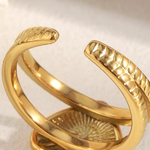 Détail macro de la bague ouverte en acier inoxydable doré 18K avec motifs tressés