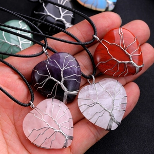 Detailed cluster of assorted crystal heart necklaces with tree of life wire wrapping
