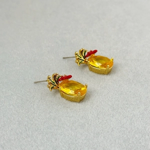 Detailed view of pineapple earrings with yellow gemstones and 925 silver needles