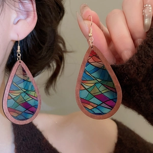 Detailed view of teardrop earrings with colorful geometric patterns and gold hooks