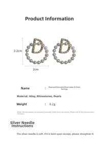 Détail de boucles d'oreilles dorées avec perles, strass et design de cerceau en D