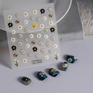 Detailed macro view of 5D daisy and bee embossed nail art stickers on display