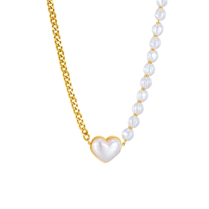 Asymmetrical stainless steel necklace featuring gold Cuban chain and white heart pendant